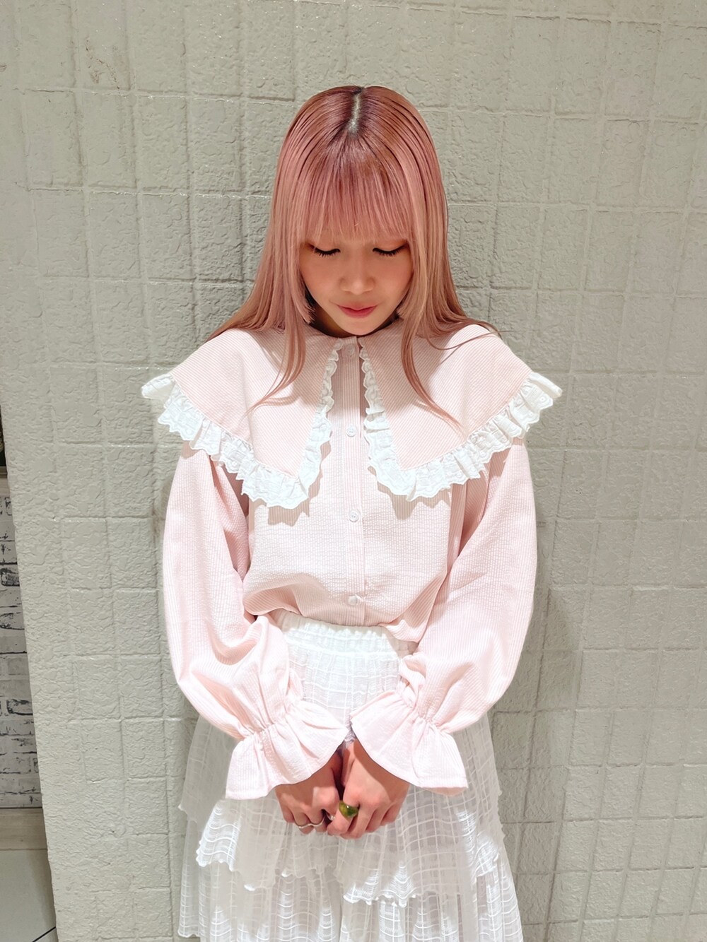 ピンク系のシャツ/ブラウス、ホワイト系のスカート、ピンク系のパンプスを着用したレディースの春コーディネートの4枚目の写真