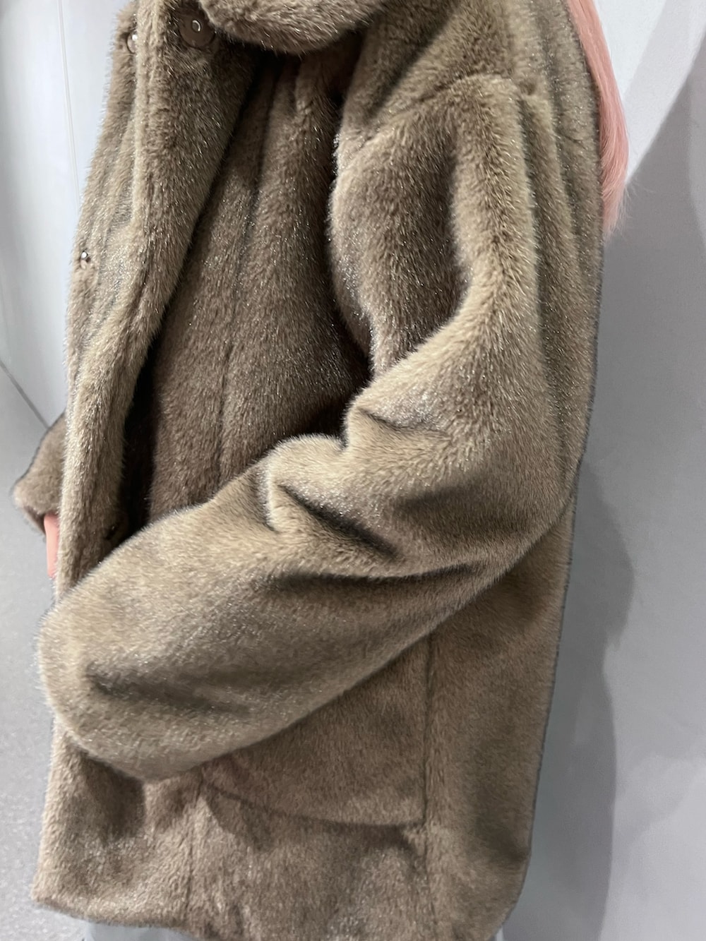 ブラウン系のノーカラーコート、グレー系のワンピース、ブルー系のデニムパンツを着用したレディースの冬コーディネートの8枚目の写真