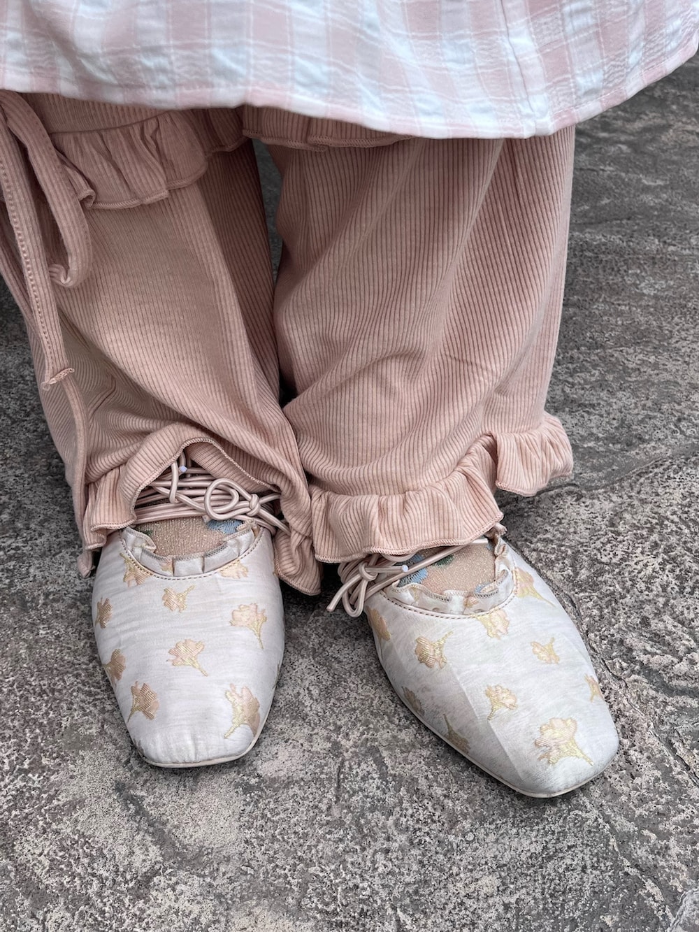 ピンク系のワンピース、ピンク系のスウェットパンツ、ゴールド系のバレエシューズを着用したレディースの春コーディネートの9枚目の写真