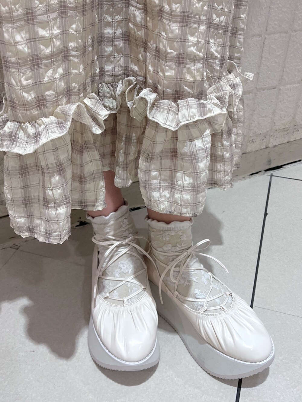 ベージュ系のワンピース、ホワイト系のTシャツ/カットソー、ホワイト系のバレエシューズを着用したレディースの春コーディネートの7枚目の写真