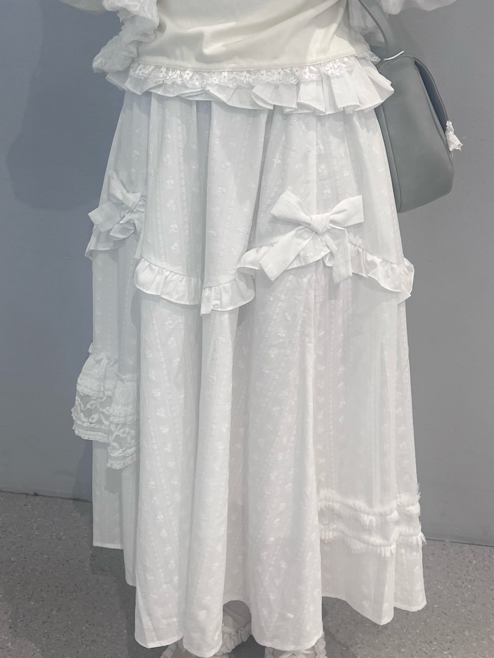 ホワイト系のスカート、ホワイト系のバレエシューズ、ブルー系のショルダーバッグを着用したレディースの春コーディネートの8枚目の写真