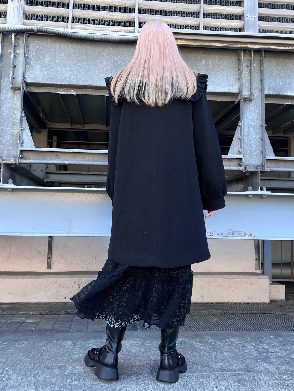 ブラック系のチェスターコート、ブラック系のワンピース、ブラック系のワンピースを着用したレディースの冬コーディネートの3枚目の写真