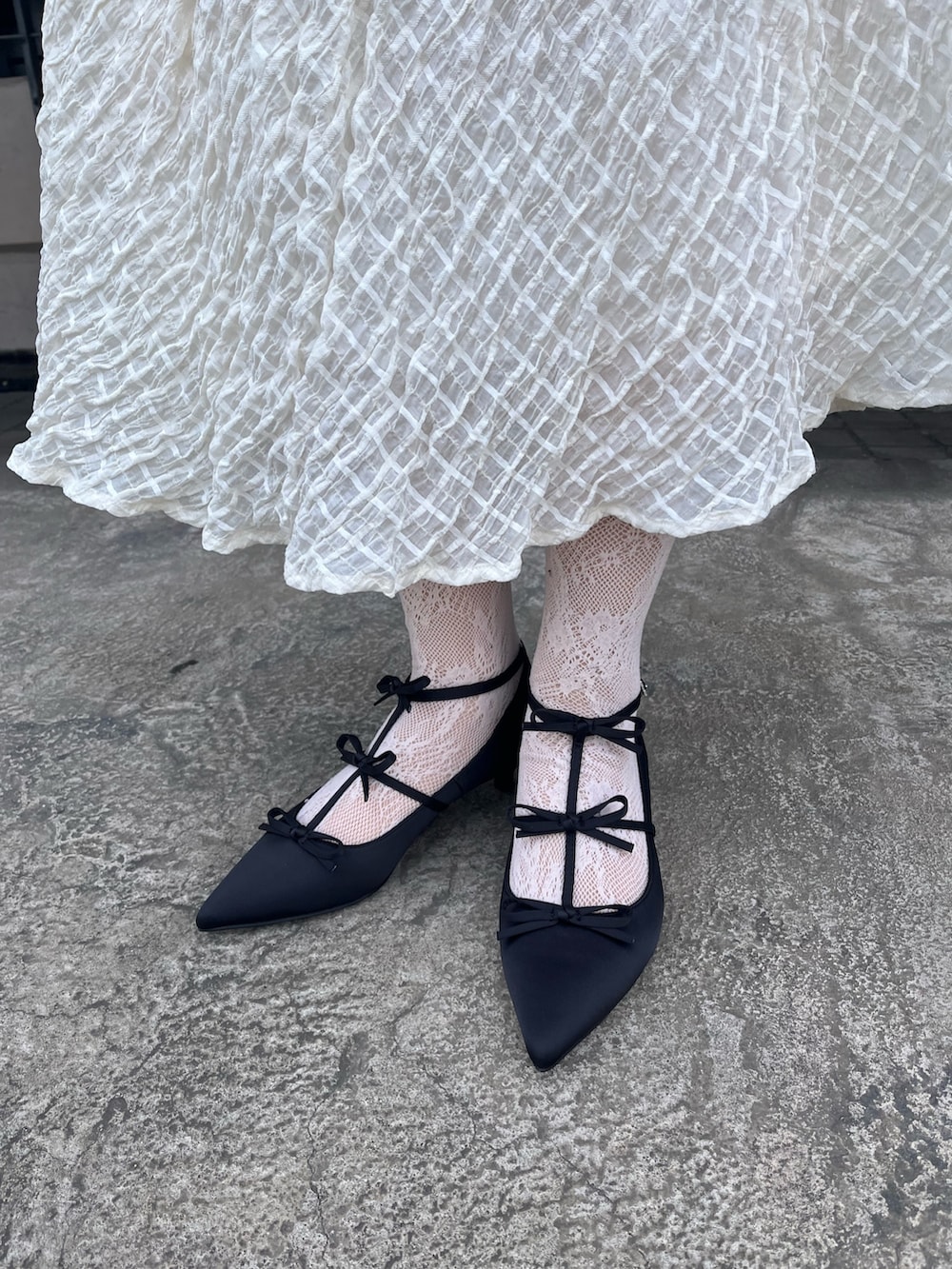 グレー系のテーラードジャケット、ホワイト系のTシャツ/カットソー、ホワイト系のスカートを着用したレディースの冬コーディネートの6枚目の写真