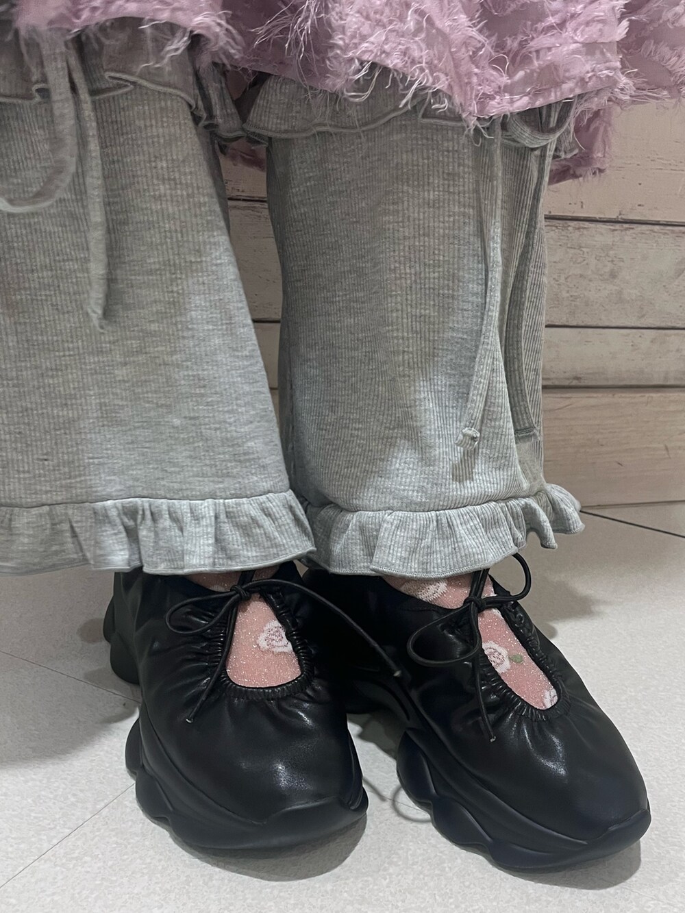 ピンク系のワンピース、グレー系のスウェットパンツ、ブラック系のスニーカーを着用したレディースの夏コーディネートの10枚目の写真