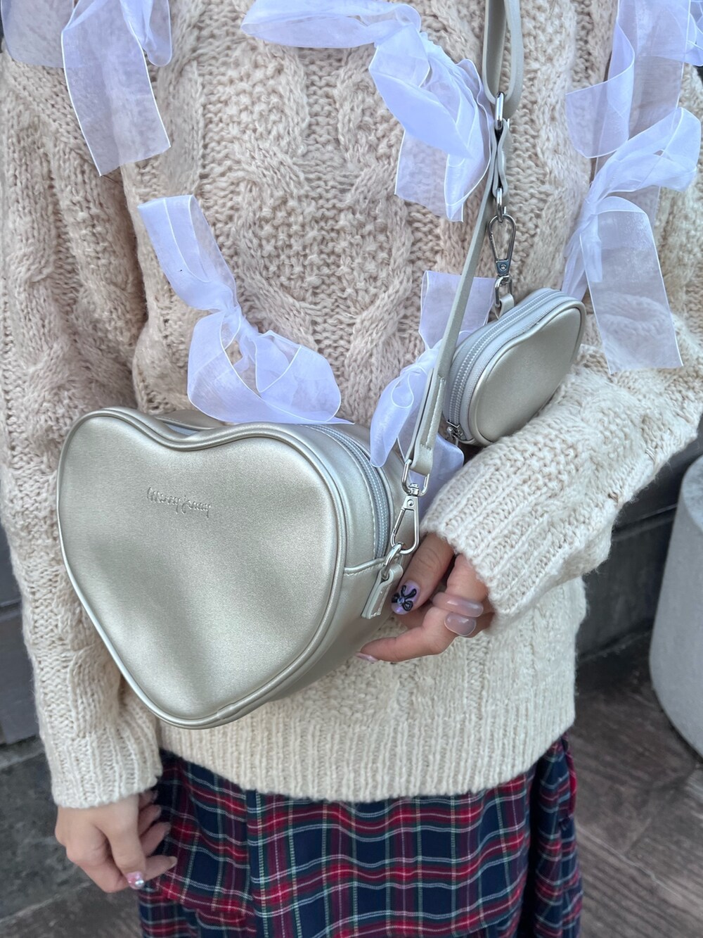 ホワイト系のニット/セーター、シルバー系のハンドバッグ、ブルー系のスカートを着用したレディースの秋コーディネートの5枚目の写真