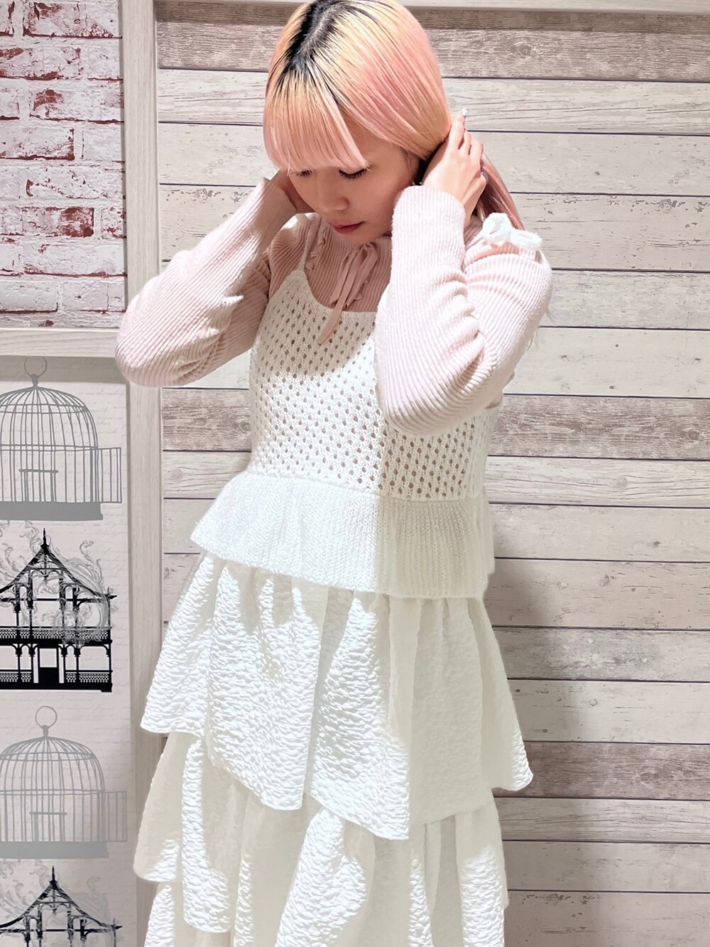 ピンク系のニット/セーター、ホワイト系のキャミソール、ホワイト系のスカートを着用したレディースの冬コーディネートの6枚目の写真