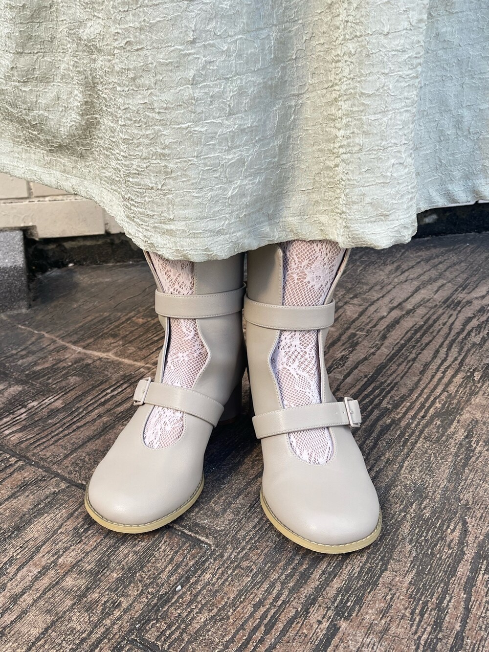 ベージュ系のブーツ、グリーン系のワンピース、ホワイト系のニット/セーターを着用したレディースの冬コーディネートの7枚目の写真