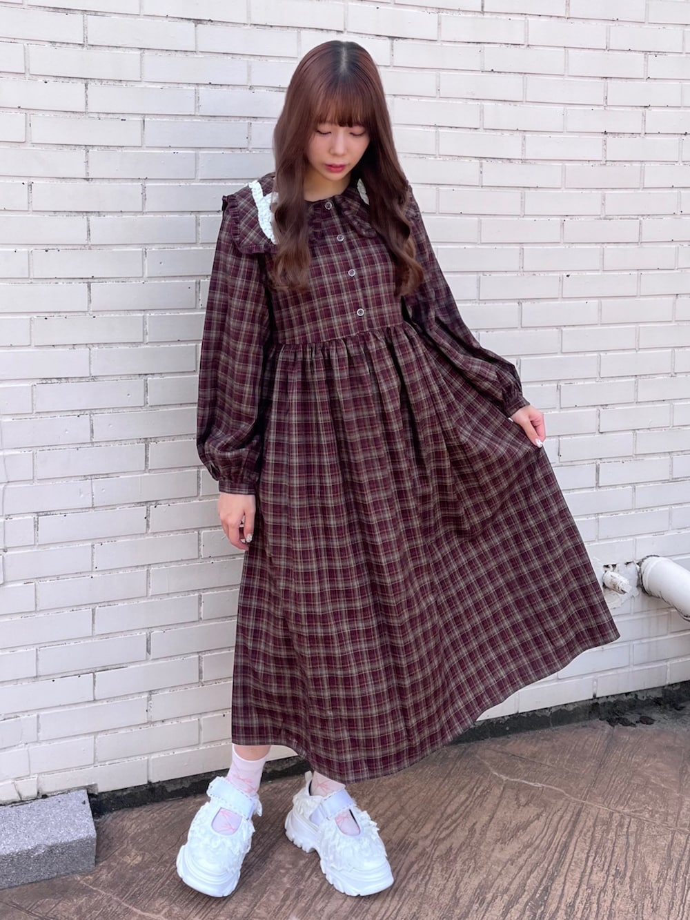 レッド系のワンピース、ホワイト系のサンダルを着用したレディースの秋コーディネートの2枚目の写真