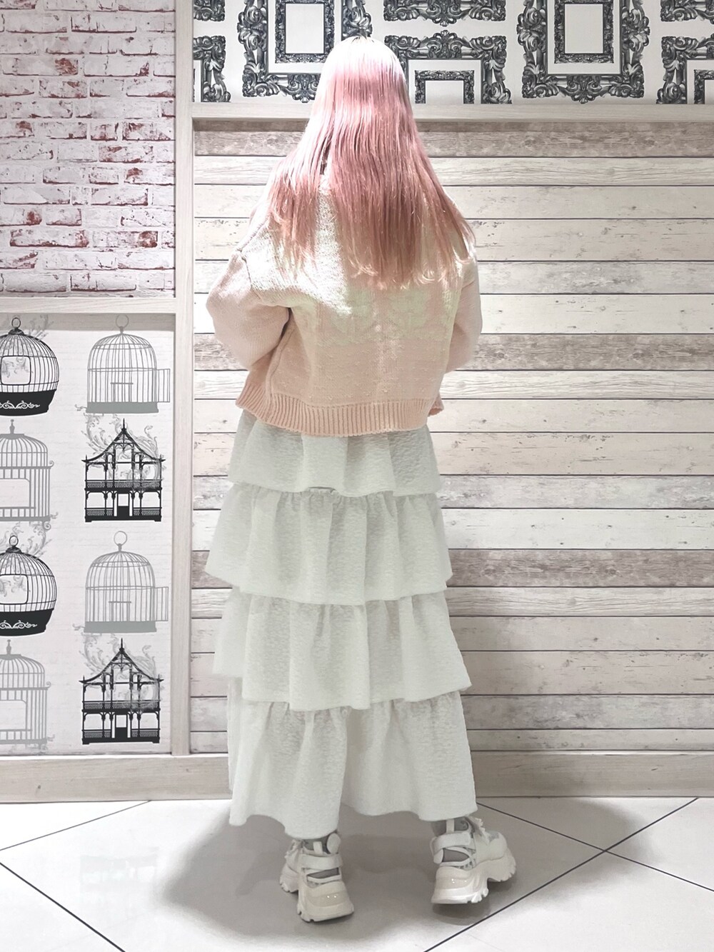 ピンク系のニット/セーター、ホワイト系のキャミソール、ホワイト系のスカートを着用したレディースの冬コーディネートの4枚目の写真