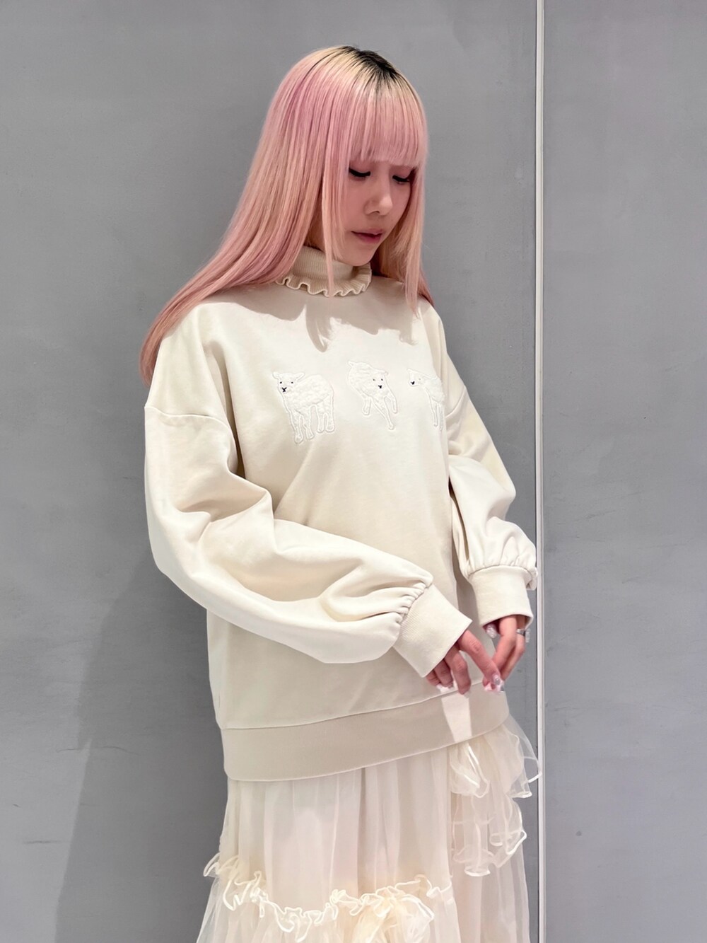 ピンク系のブルゾン、ベージュ系のスウェット、ホワイト系のニット/セーターを着用したレディースの冬コーディネートの4枚目の写真