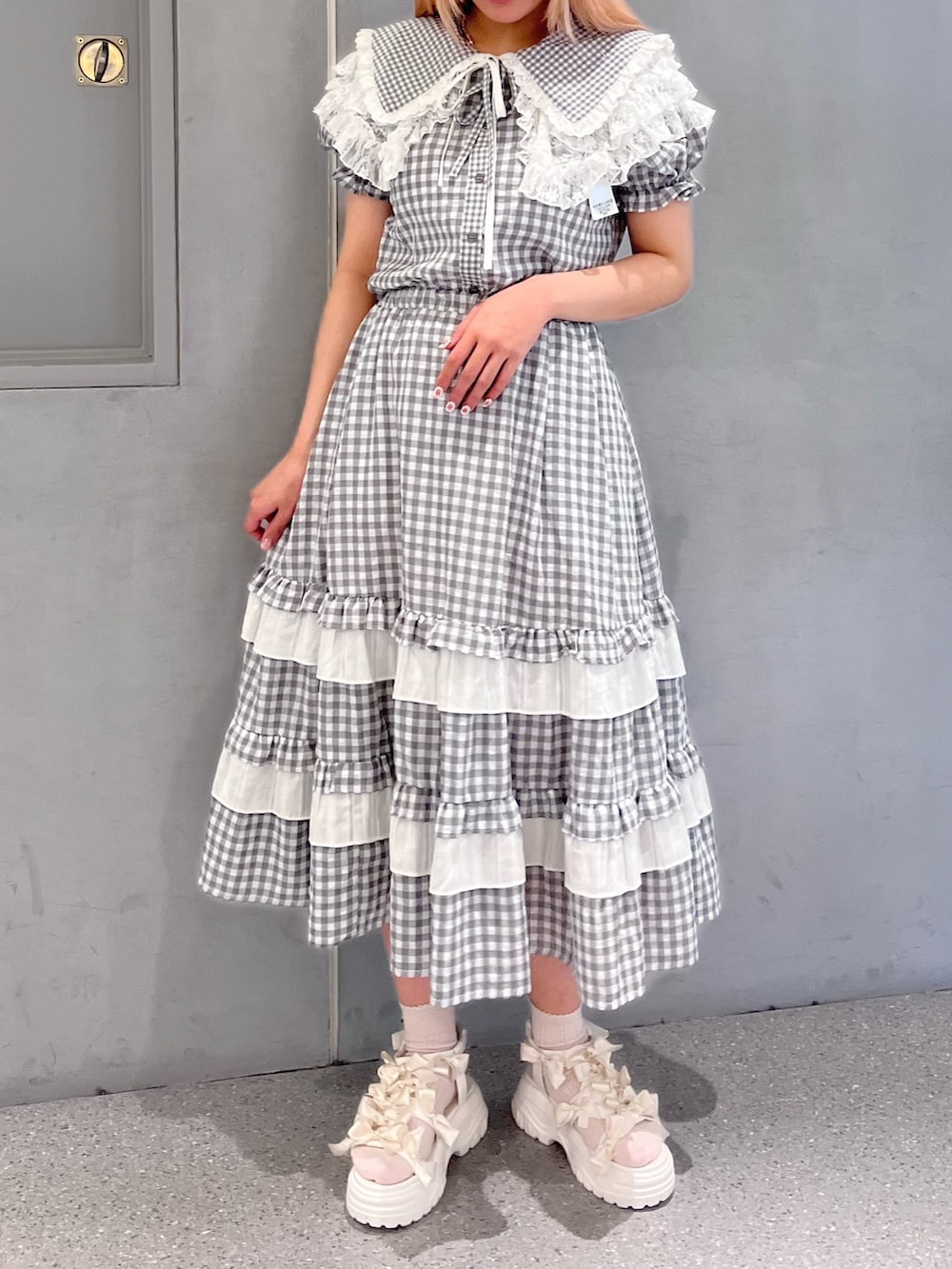 グレー系のシャツ/ブラウス、グレー系のスカート、ホワイト系のサンダルを着用したレディースの春コーディネートの2枚目の写真