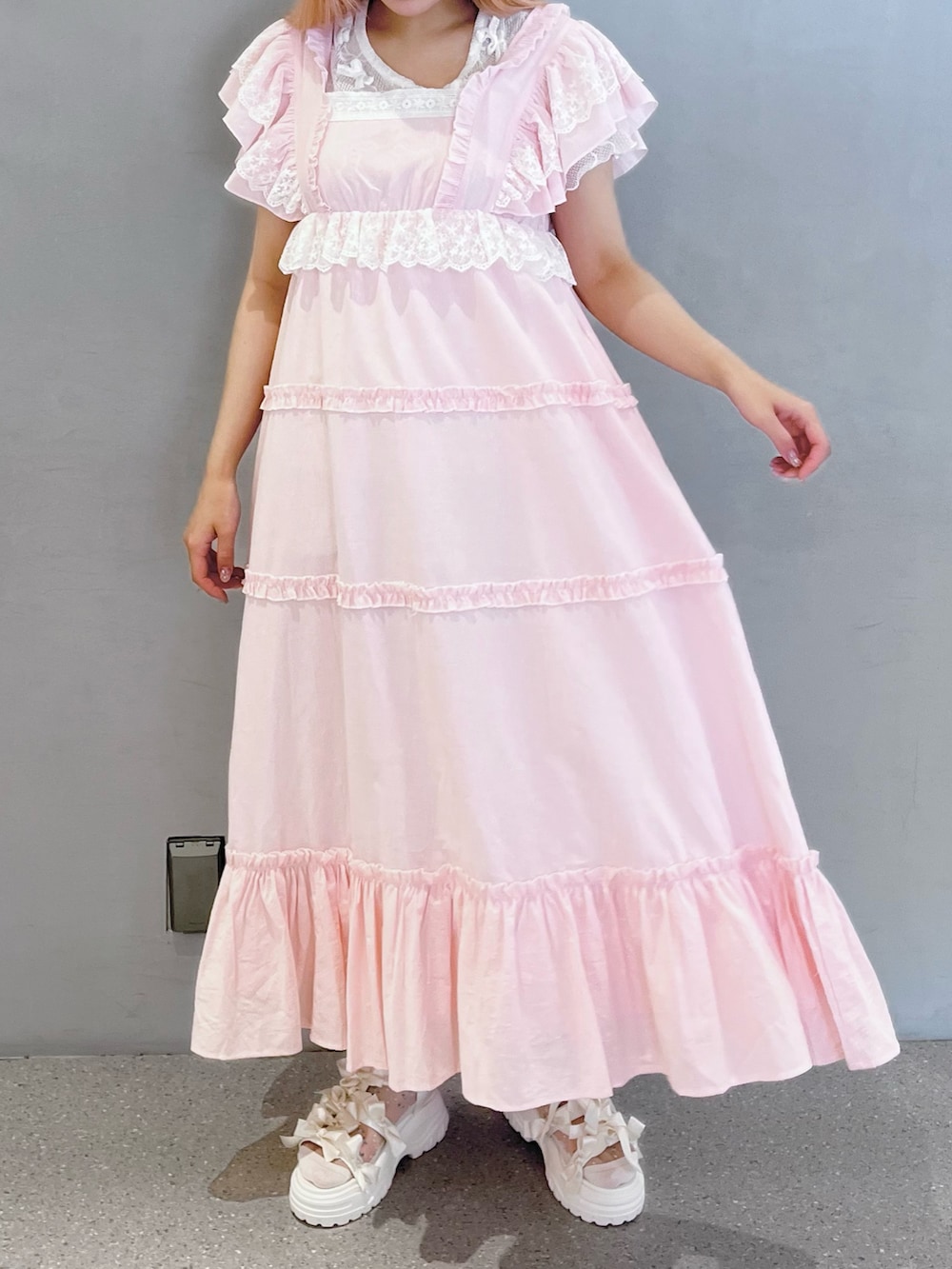 ピンク系のワンピース、ホワイト系のTシャツ/カットソー、ホワイト系のサンダルを着用したレディースの夏コーディネートの2枚目の写真