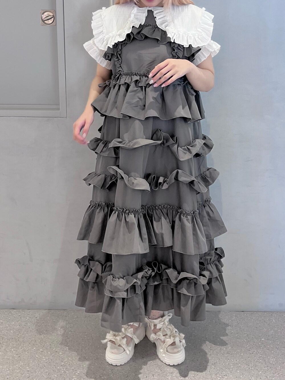 グレー系のワンピース、ホワイト系のシャツ/ブラウス、ホワイト系のサンダルを着用したレディースの夏コーディネートの2枚目の写真