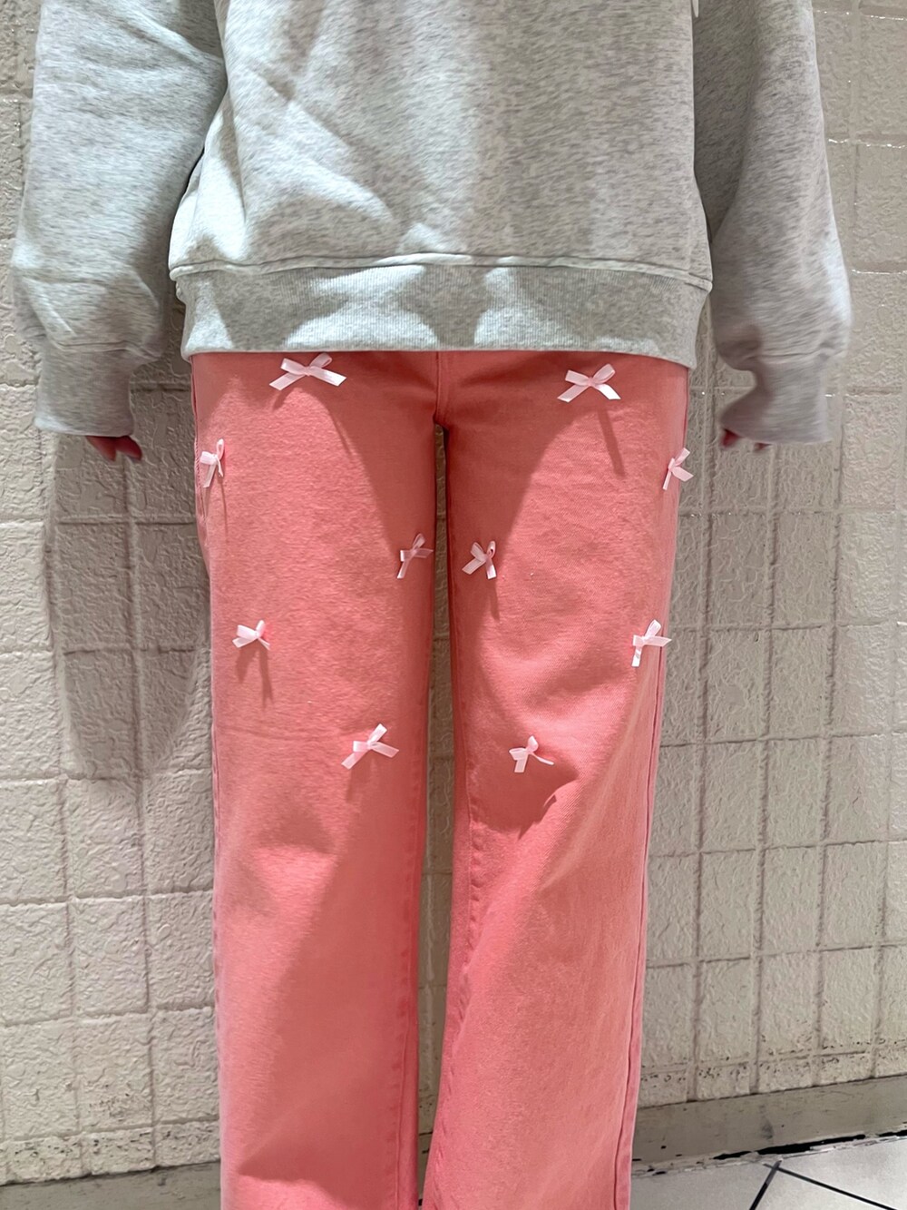 ホワイト系のスウェット、ピンク系のTシャツ/カットソー、ピンク系のデニムパンツを着用したレディースの冬コーディネートの6枚目の写真