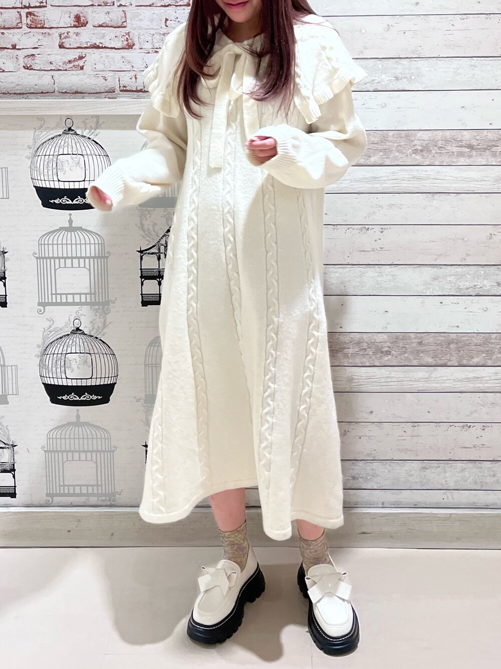 ホワイト系のワンピース、ホワイト系のローファーを着用したレディースの冬コーディネートの2枚目の写真