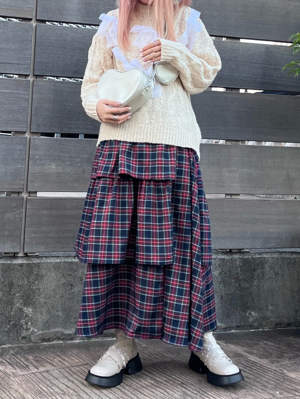 ホワイト系のニット/セーター、シルバー系のハンドバッグ、ブルー系のスカートを着用したレディースの秋コーディネートの2枚目の写真