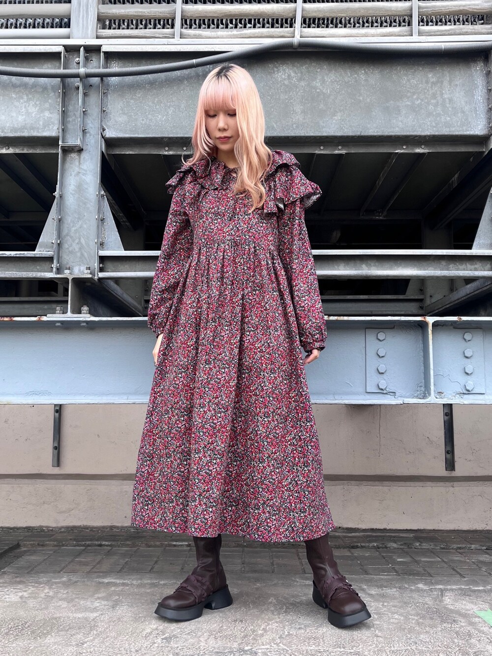 ブラック系のカーディガン/ボレロ、ピンク系のワンピース、ブラウン系のブーツを着用したレディースの秋コーディネートの2枚目の写真