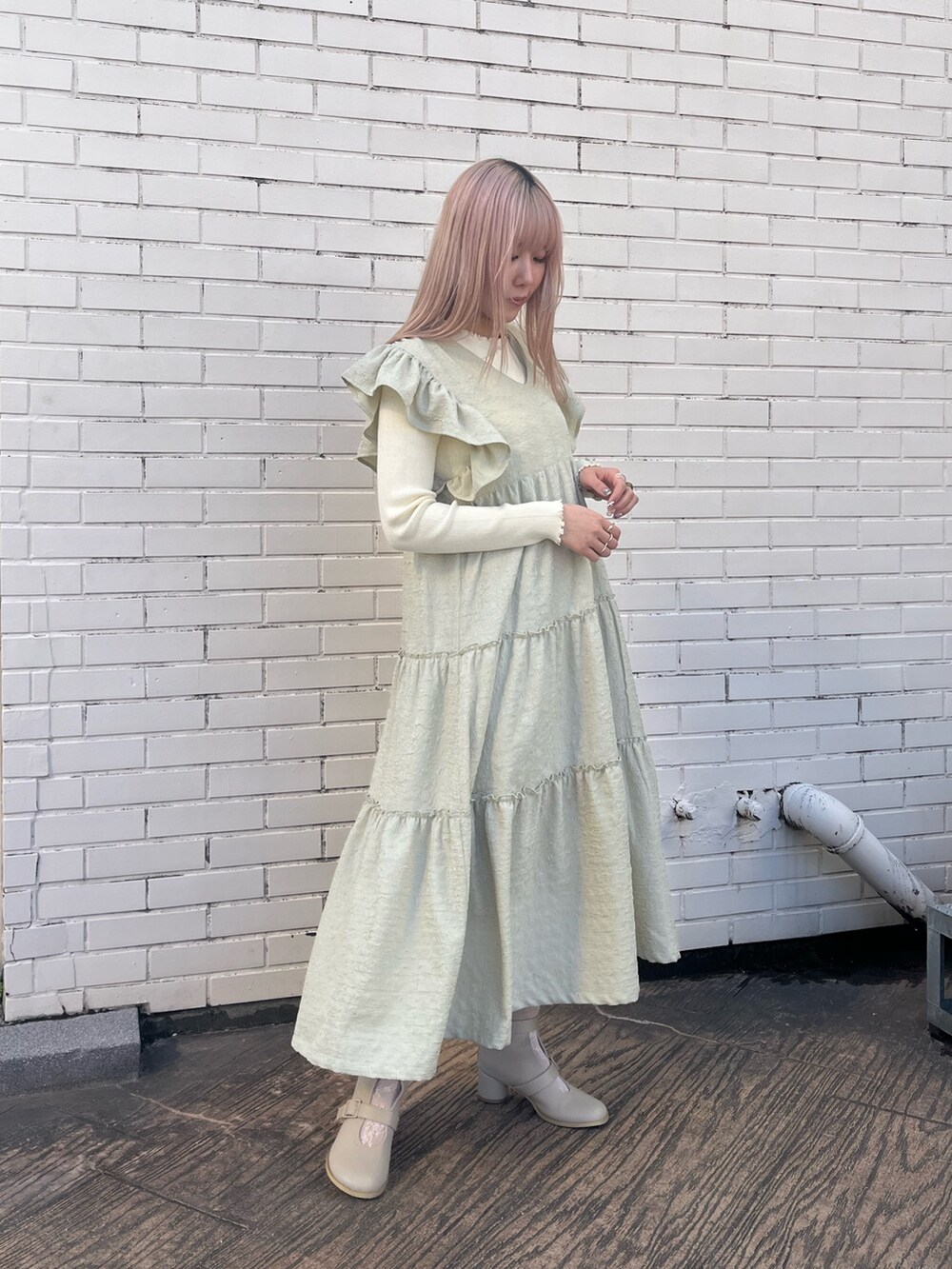 ベージュ系のブーツ、グリーン系のワンピース、ホワイト系のニット/セーターを着用したレディースの冬コーディネートの3枚目の写真