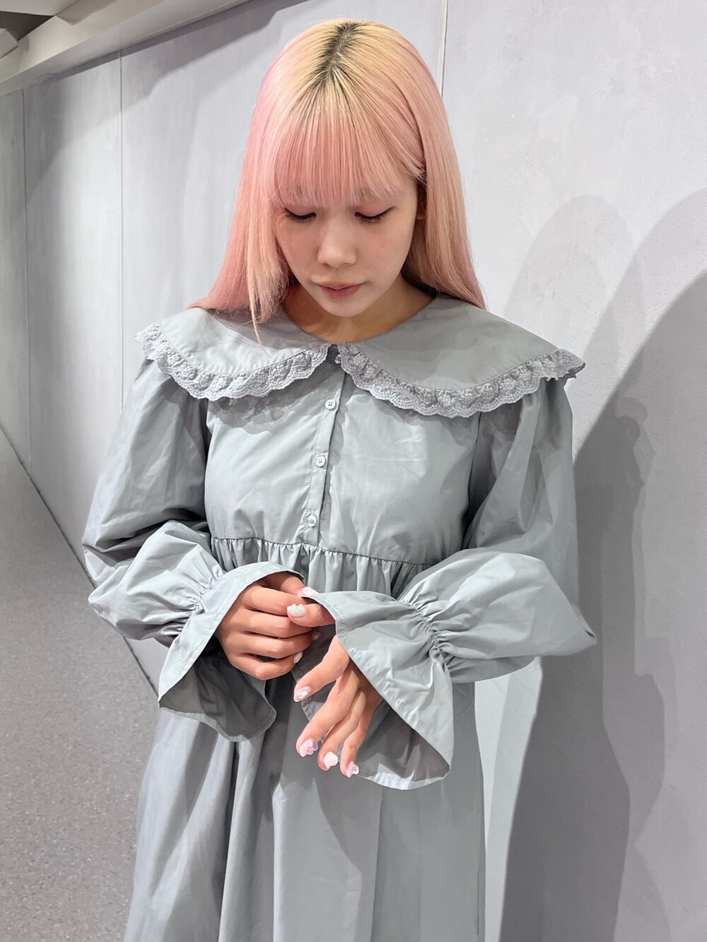 ブラウン系のノーカラーコート、グレー系のワンピース、ブルー系のデニムパンツを着用したレディースの冬コーディネートの6枚目の写真