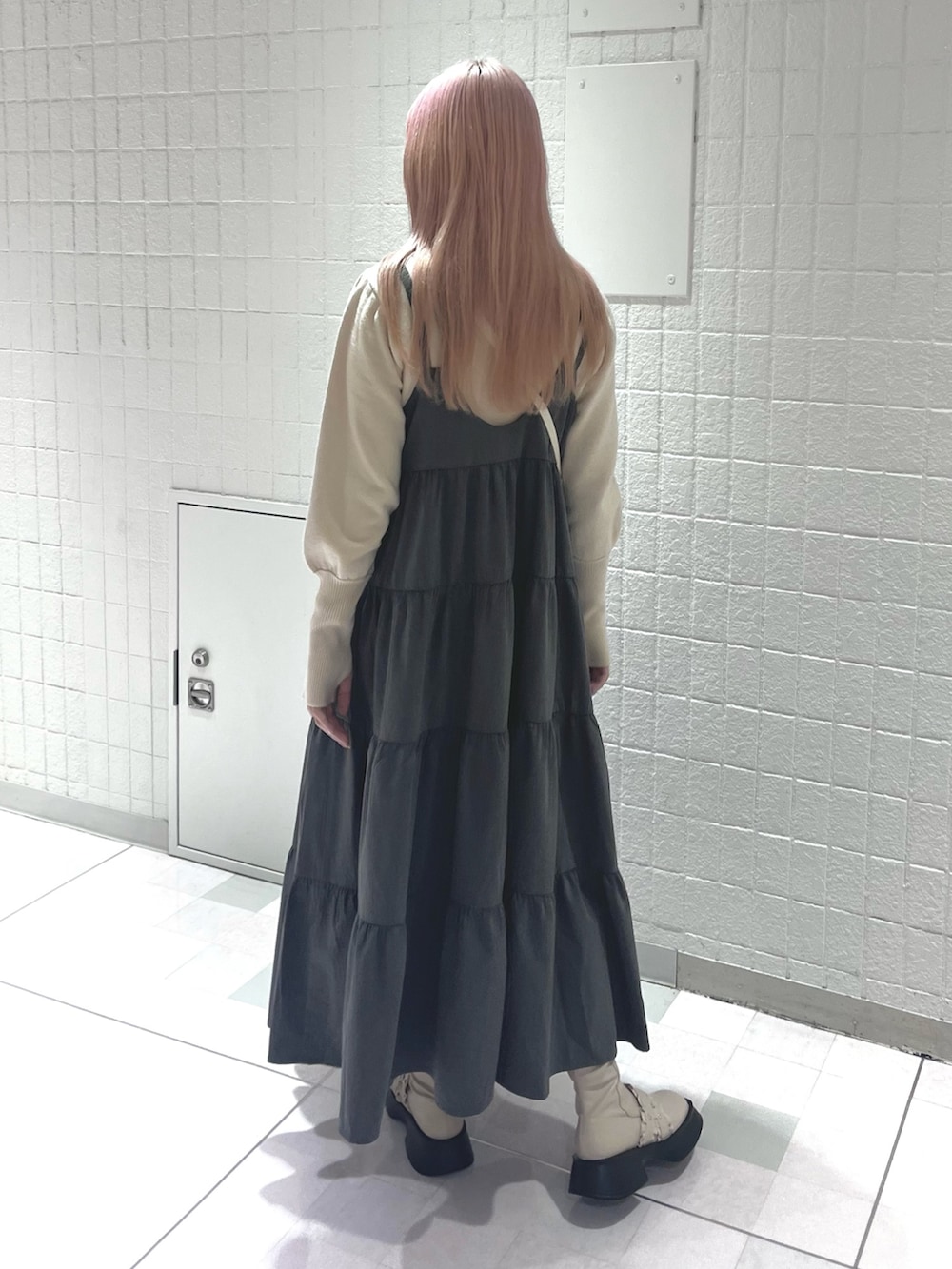 ホワイト系のニット/セーター、グレー系のワンピース、ホワイト系のハンドバッグを着用したレディースの秋コーディネートの4枚目の写真