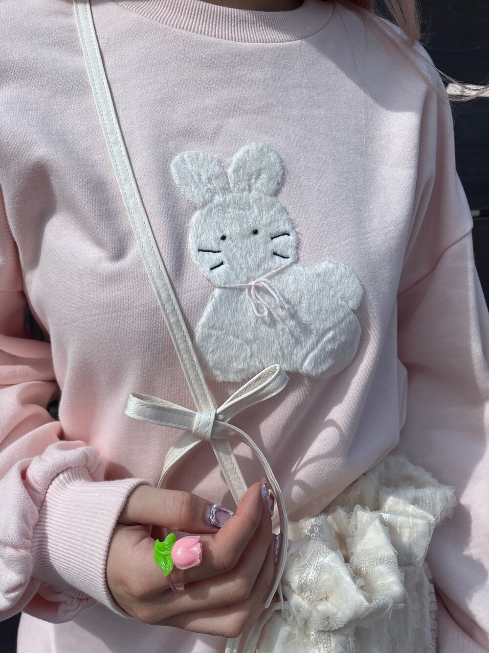 ピンク系のスウェット、ブルー系のスカート、ホワイト系のバレエシューズを着用したレディースの春コーディネートの7枚目の写真