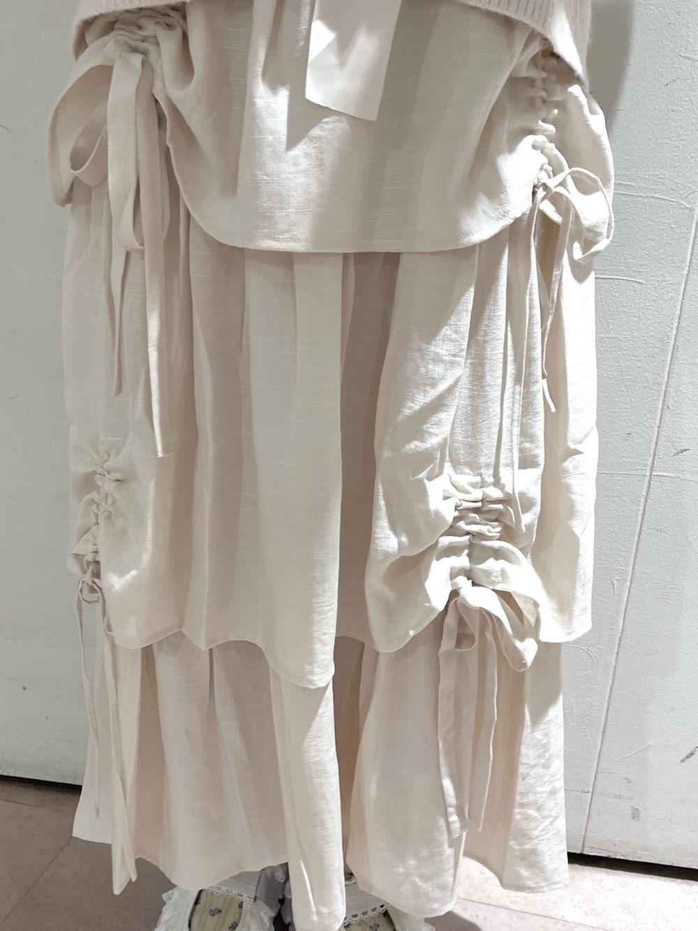 ホワイト系のカーディガン/ボレロ、グレー系のニット/セーター、ホワイト系のスカートを着用したレディースの秋コーディネートの8枚目の写真