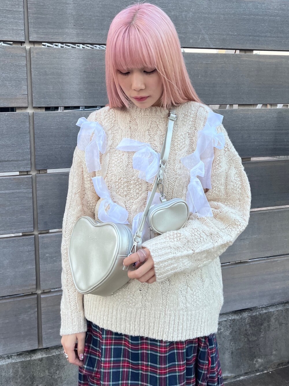 ホワイト系のニット/セーター、シルバー系のハンドバッグ、ブルー系のスカートを着用したレディースの秋コーディネートの4枚目の写真