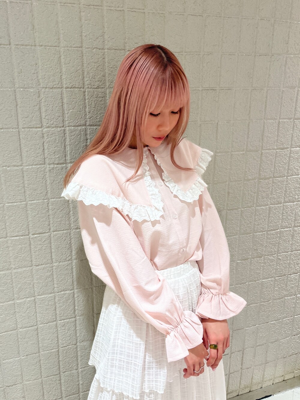 ピンク系のシャツ/ブラウス、ホワイト系のスカート、ピンク系のパンプスを着用したレディースの春コーディネートの5枚目の写真