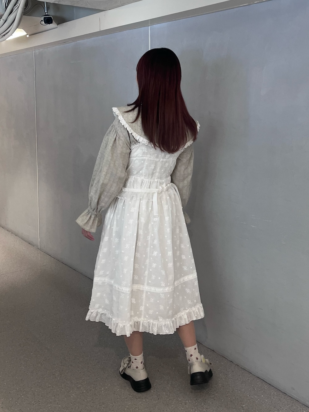 ホワイト系のワンピース、グリーン系のシャツ/ブラウス、ホワイト系のスニーカーを着用したレディースの春コーディネートの3枚目の写真