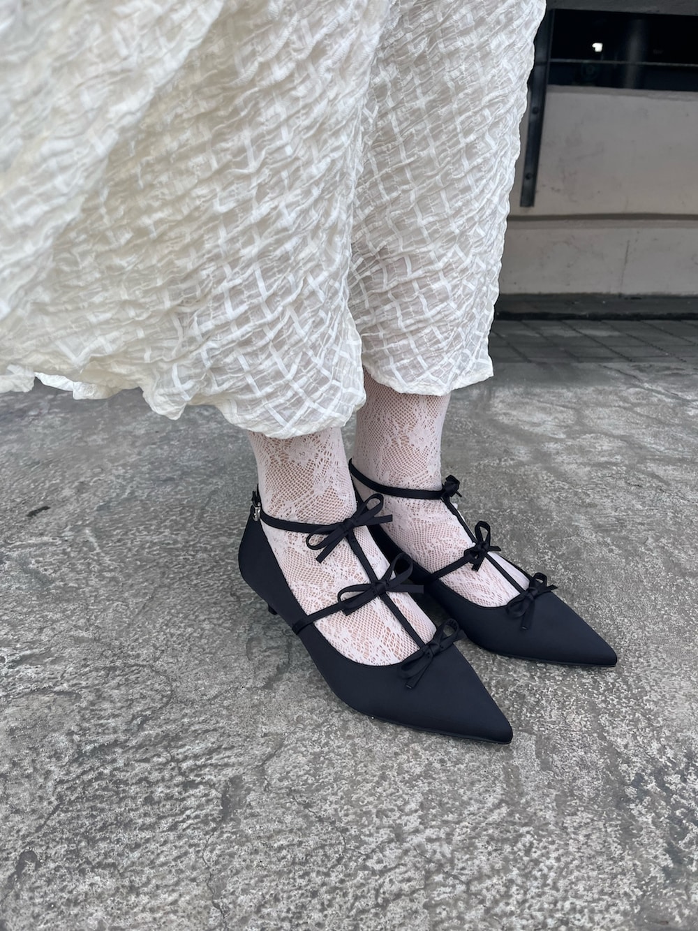 グレー系のテーラードジャケット、ホワイト系のTシャツ/カットソー、ホワイト系のスカートを着用したレディースの冬コーディネートの7枚目の写真