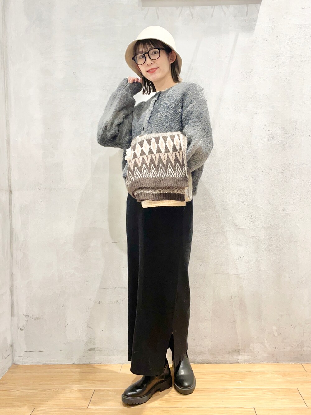 ブラック系のワンピース、ブラック系のブーツ、ベージュ系のハットを着用したレディースの冬コーディネートの4枚目の写真