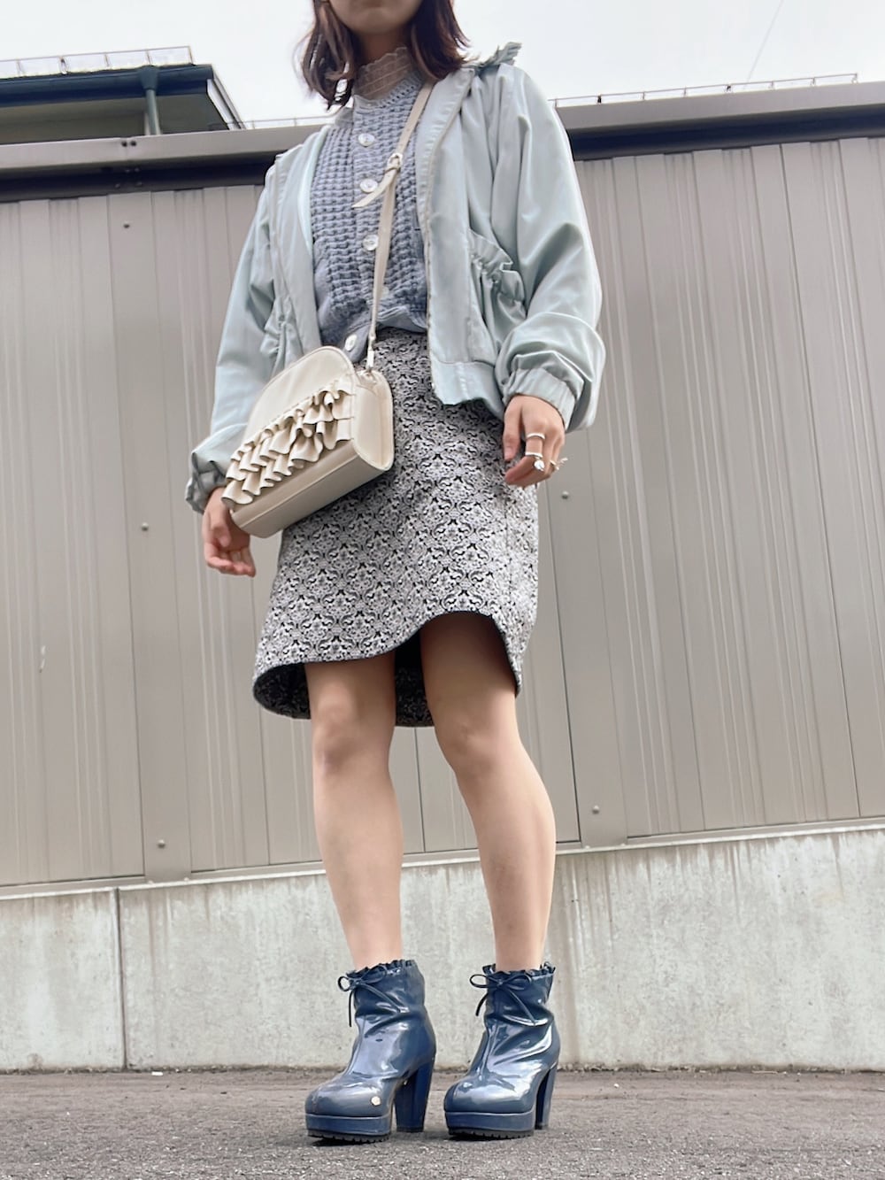 ホワイト系のショルダーバッグ、ブルー系のジャケット/アウター、ブラック系のスカートを着用したレディースの冬コーディネートの2枚目の写真