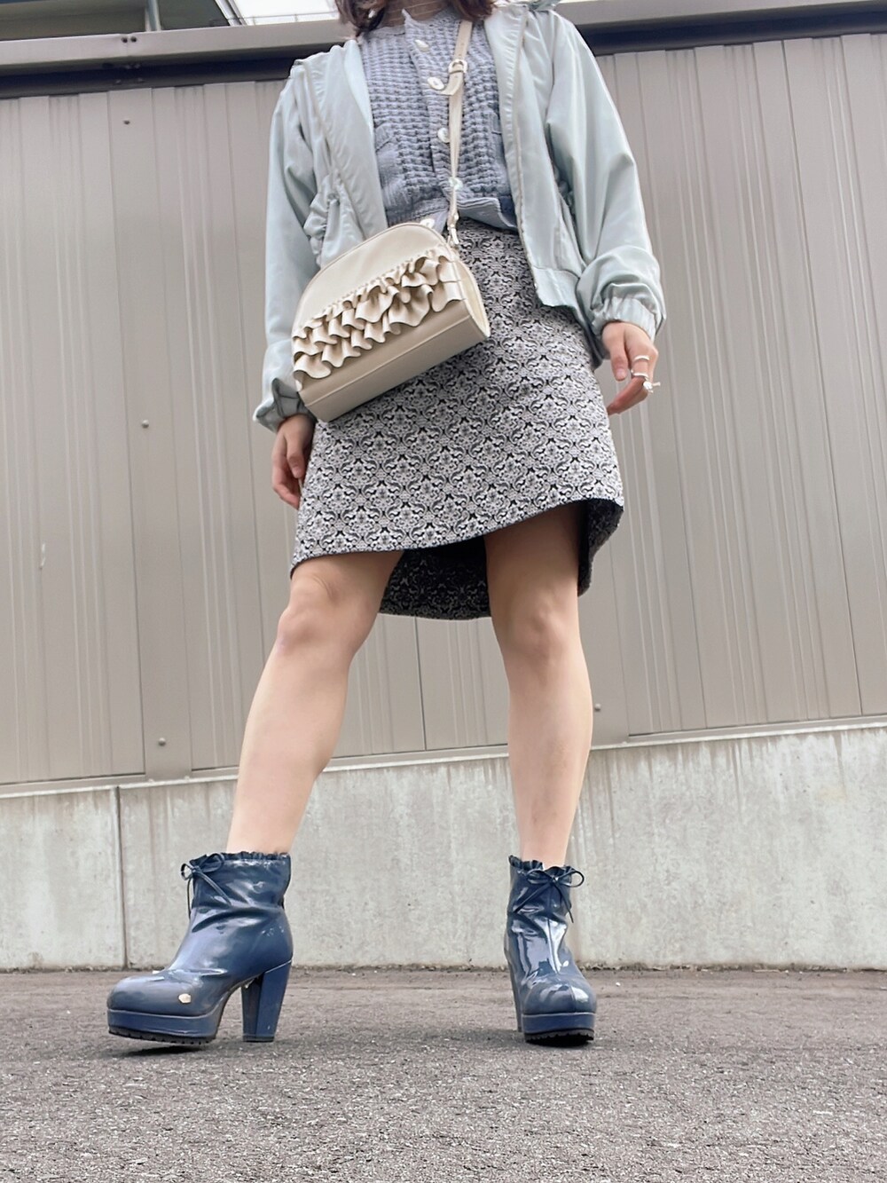 ホワイト系のショルダーバッグ、ブルー系のジャケット/アウター、ブラック系のスカートを着用したレディースの冬コーディネートの4枚目の写真