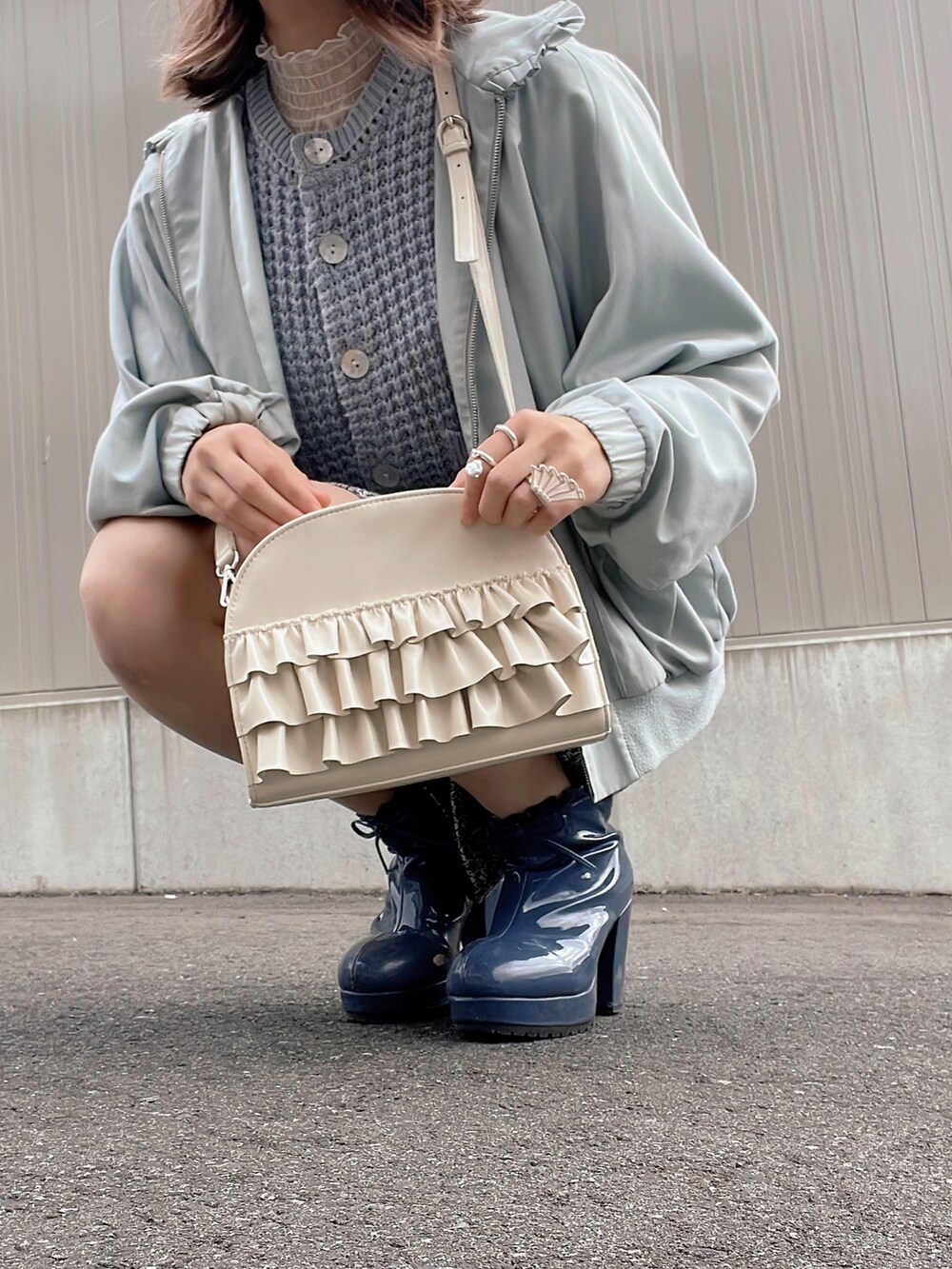 ホワイト系のショルダーバッグ、ブルー系のジャケット/アウター、ブラック系のスカートを着用したレディースの冬コーディネートの3枚目の写真