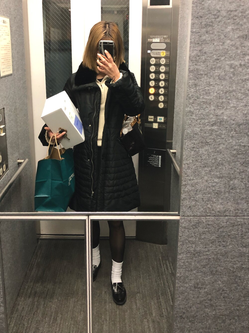 ブラック系のスカート、ブラック系のローファーを着用したレディースの冬コーディネートの2枚目の写真