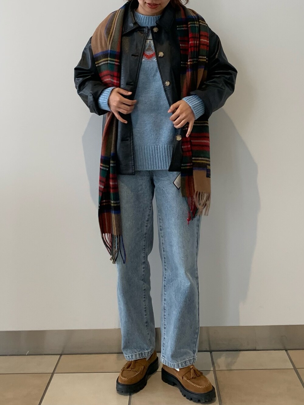 ブルー系のデニムパンツ、ブラック系のブルゾン、ブルー系のニット/セーターを着用したレディースの秋コーディネートの2枚目の写真