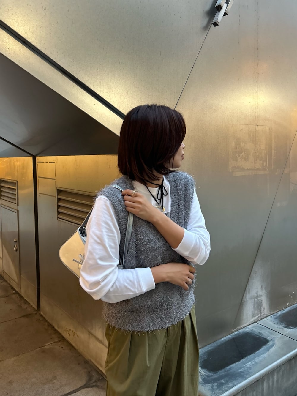 グリーン系のその他パンツ、グレー系のベスト、シルバー系のハンドバッグを着用したレディースの秋コーディネートの5枚目の写真