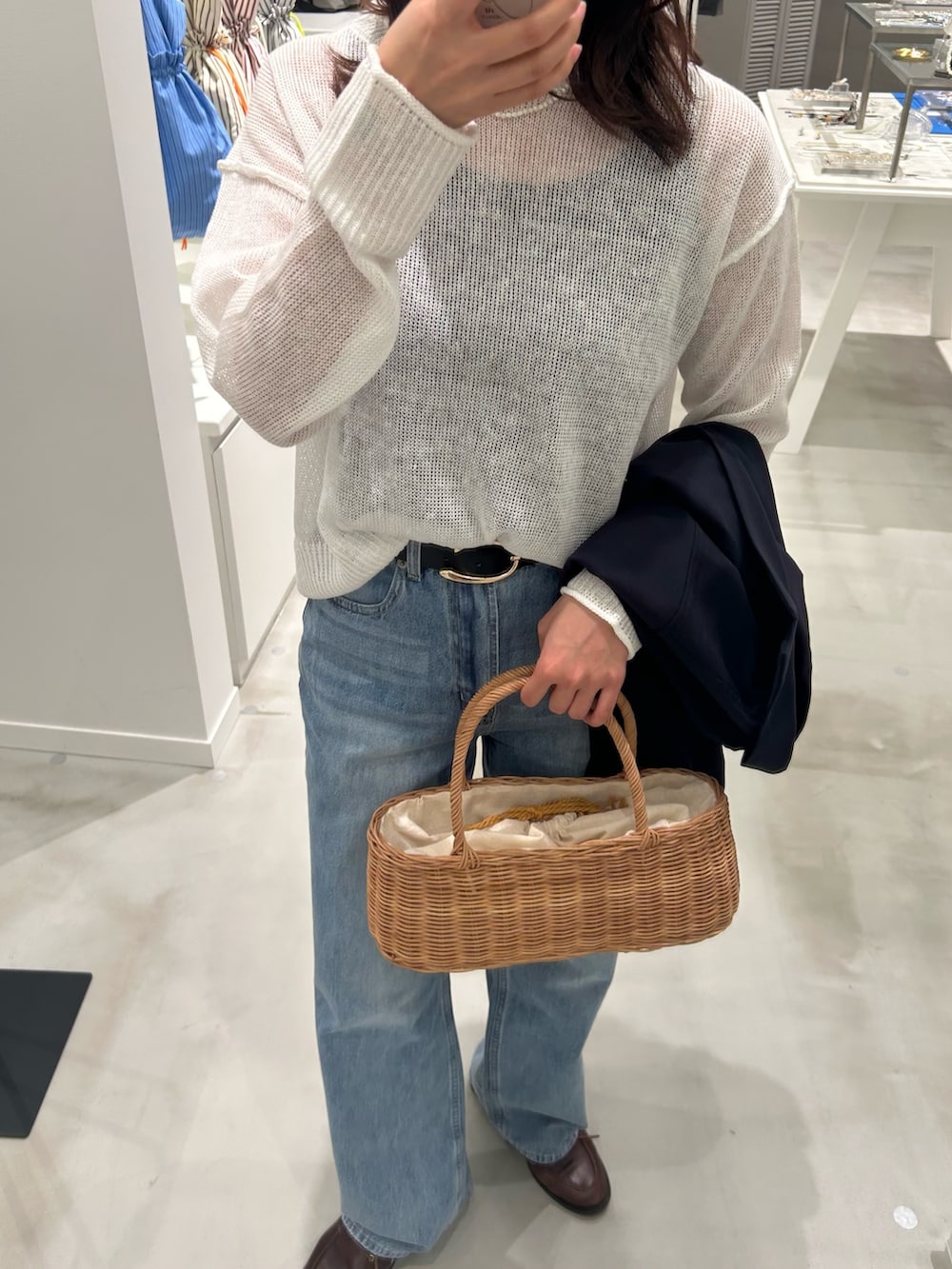 ホワイト系のニット/セーター、ブルー系のデニムパンツ、ブルー系のシャツ/ブラウスを着用したレディースの春コーディネートの4枚目の写真