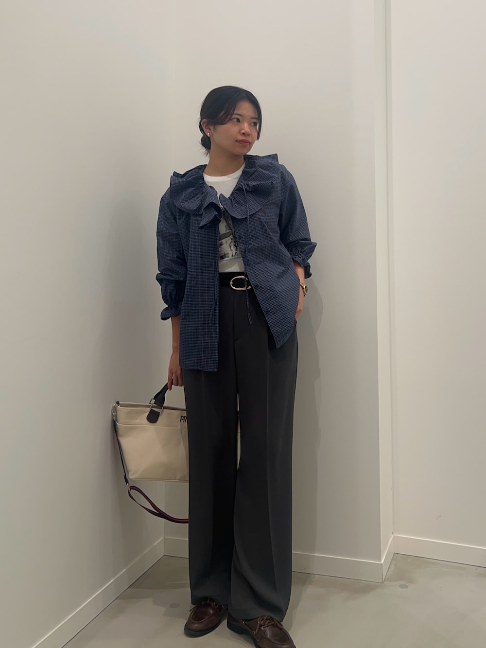 ホワイト系のTシャツ/カットソー、グレー系のスラックス、ホワイト系のショルダーバッグを着用したレディースの春コーディネートの3枚目の写真