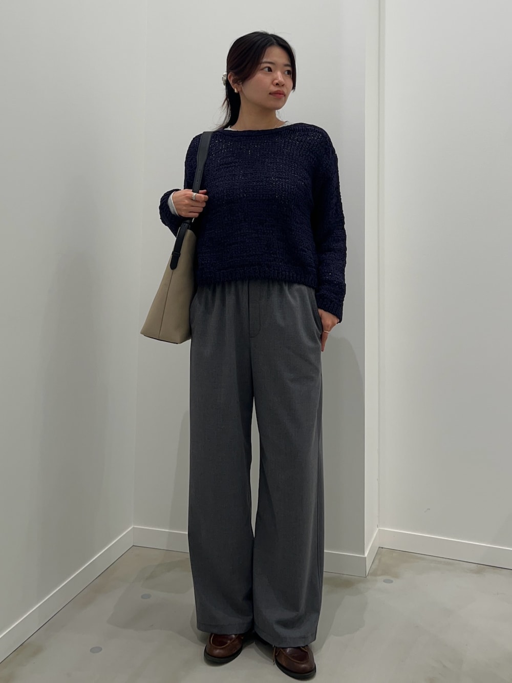 ブルー系のニット/セーター、グレー系のTシャツ/カットソー、グレー系のその他パンツを着用したレディースの春コーディネートの2枚目の写真