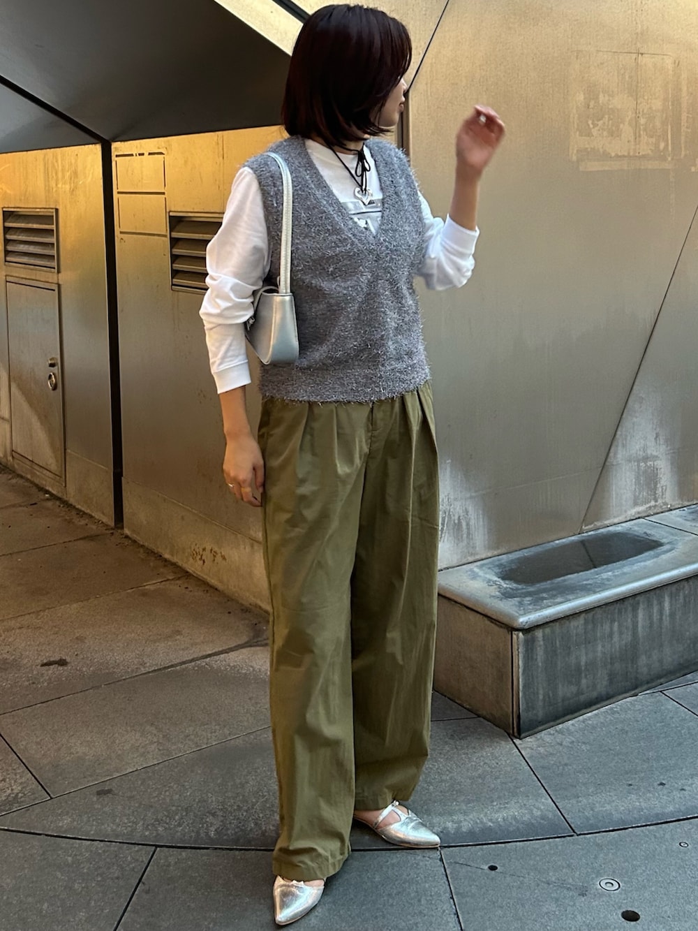 グリーン系のその他パンツ、グレー系のベスト、シルバー系のハンドバッグを着用したレディースの秋コーディネートの2枚目の写真
