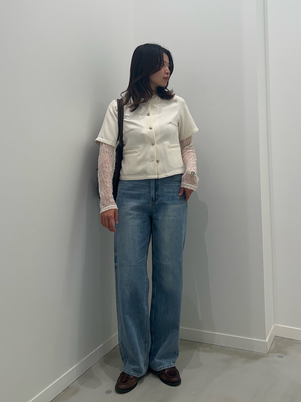 ブルー系のデニムパンツ、ホワイト系のTシャツ/カットソー、ホワイト系のノーカラージャケットを着用したレディースの春コーディネートの2枚目の写真