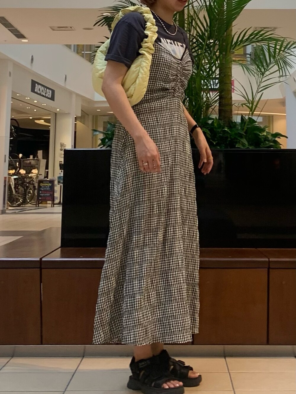 ブラック系のワンピース、グレー系のTシャツ/カットソー、イエロー系のショルダーバッグを着用したレディースの夏コーディネートの4枚目の写真