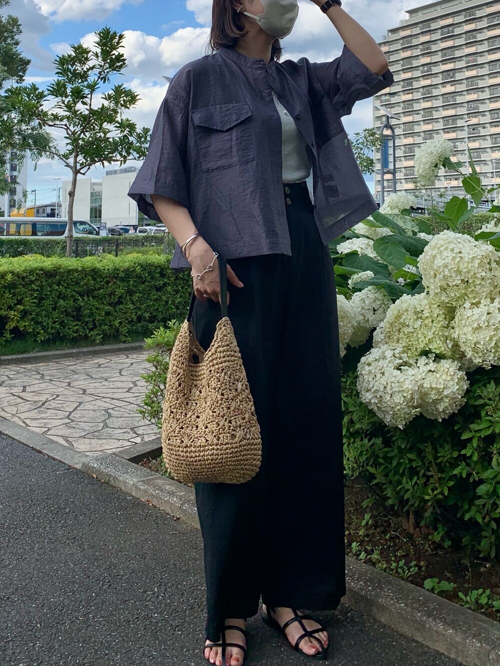 ブラック系のかごバッグ、ブラック系のスラックス、グレー系のシャツ/ブラウスを着用したレディースの夏コーディネートの2枚目の写真