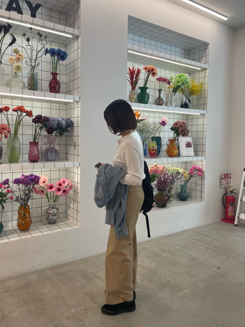 ベージュ系のその他パンツ、ホワイト系のカーディガン/ボレロ、ブルー系のシャツ/ブラウスを着用したレディースの春コーディネートの6枚目の写真
