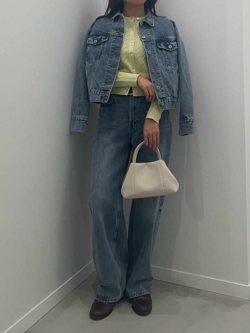 ブルー系のデニムパンツ、ブルー系のデニムジャケット、グリーン系のカーディガン/ボレロを着用したレディースの冬コーディネートの5枚目の写真