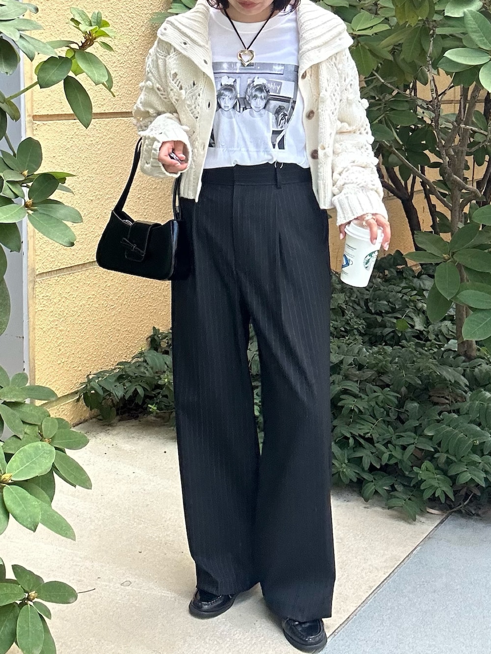 ブルー系のスラックス、ホワイト系のニット/セーター、ホワイト系のTシャツ/カットソーを着用したレディースの秋コーディネートの3枚目の写真