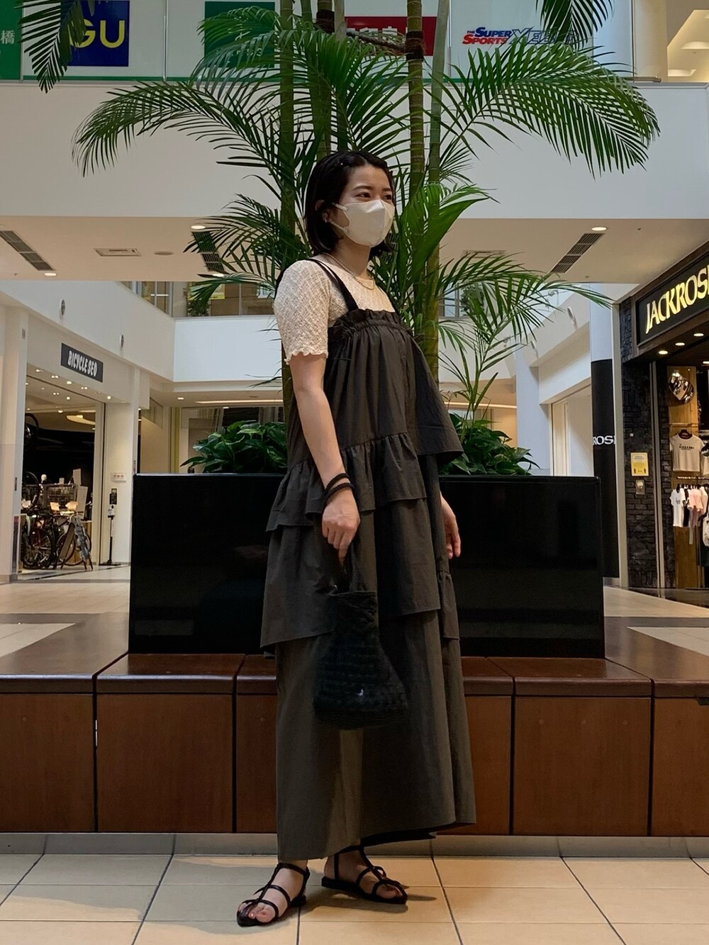 グリーン系のワンピース、ホワイト系のTシャツ/カットソー、ブラック系のトートバッグを着用したレディースの夏コーディネートの3枚目の写真