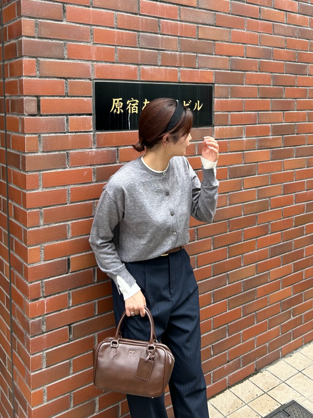 ブルー系のスラックス、ブラウン系のハンドバッグ、グレー系のカーディガン/ボレロを着用したレディースの秋コーディネートの4枚目の写真