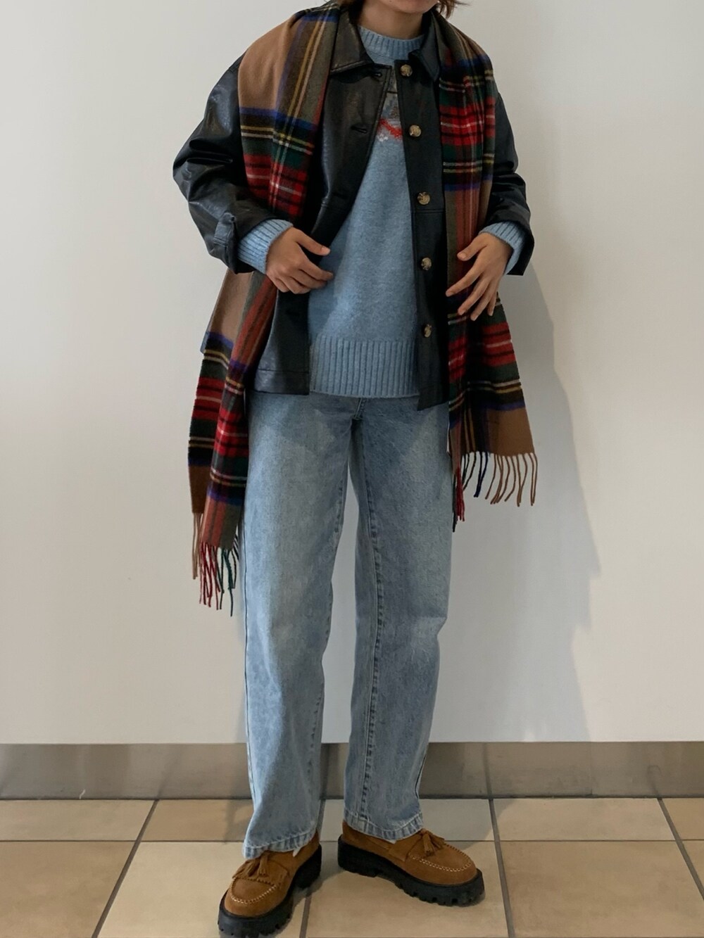 ブルー系のデニムパンツ、ブラック系のブルゾン、ブルー系のニット/セーターを着用したレディースの秋コーディネートの3枚目の写真